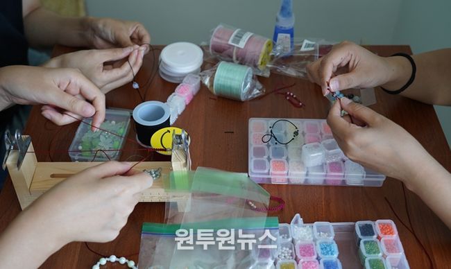 인천시청년미래센터 프로그램을 이용하는 청년들이 청년의 날 행사에서 판매할 비즈 장식 장신구를 만들고 있다.