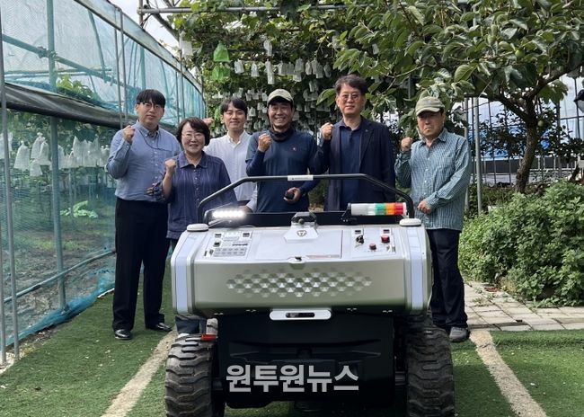 김운학 산업지원본부장(오른쪽 두번째)이 관내 농가에 운반로봇을 보급하고 기념촬영을 하고 있다.