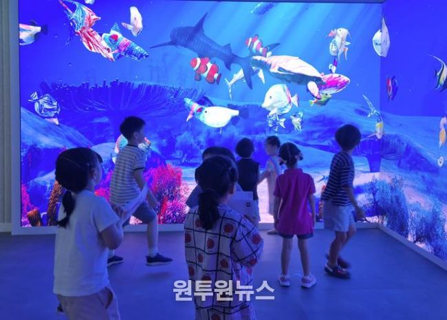 미디어 아트월 체험을 즐기는 어린이들