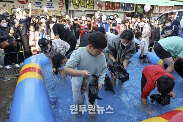 제10회 시흥월곶포구축제 중 맨손 고기잡이 체험에 참여 중인 시민들