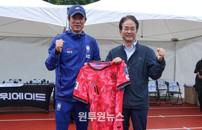 1. 국가대표팀 선수들의 친필 사인 유니폼을 들고 기념촬영 중인 이동환 고양특례시장(오른쪽)과 홍명보 축구 국가대표팀 감독(왼쪽)