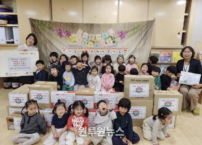 시립어반포레어린이집에서 김민경원장과 원아들이 함께 후원금품 전달식을 진행하고 있다.