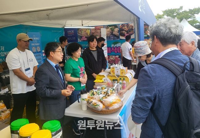 강상구 나주시 부시장(왼쪽)이 나주배 홍보관을 찾은 방문객들에게 시식을 권유하며 나주배 홍보에 열을 올리고 있다.