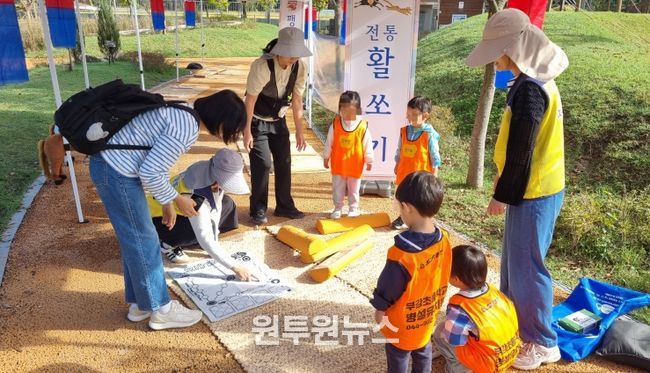 23일 무지개 축제에서 아이들이 활쏘기 체험과 멧돌을 체험해 보고 있는 모습