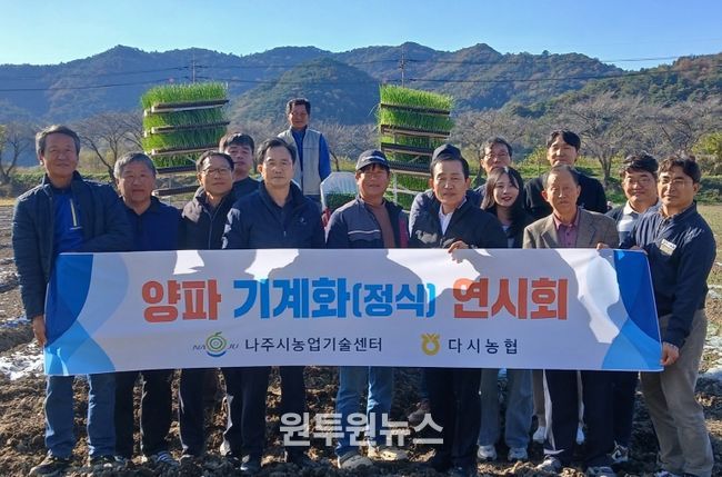 양파 기계 정식 연시회에 참가한 농업인들과 관계자들이 기념촬영을 하고 있다.