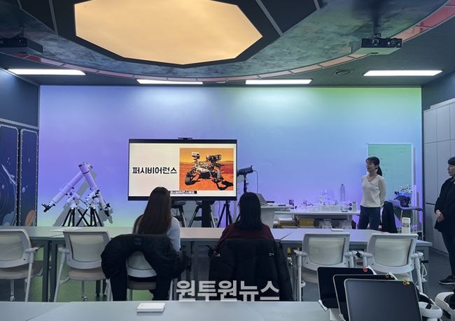 우주탐사실에서 행성 탐사 로버에 대해 교육 받는 장면
