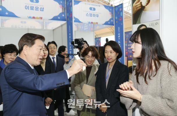 박승원 광명시장(사진 왼쪽)이 2024년 광명스피돔에서 열린 '2024 광명시 스타트업 페스티벌'의 전시·체험 부스에 참여한 기업 제품을 체험해 보고 있다.