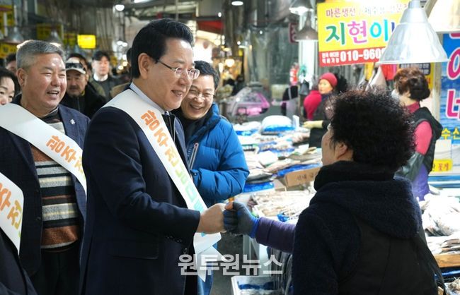 김영록 전라남도지사가 설 명절을 앞둔 15일 지역 전통시장인 광주 양동시장을 방문해 전남·광주 행정통합의 취지와 추진 방향을 설명하고 물품을 구매하며 상인들을 격려하고 있다.