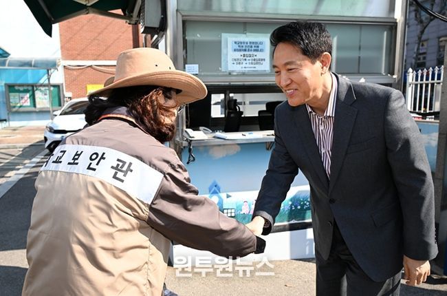 오세훈 서울시장이 13일 서울 소재 초등학교에서 학교보안관과 인사를 나누고 있다.