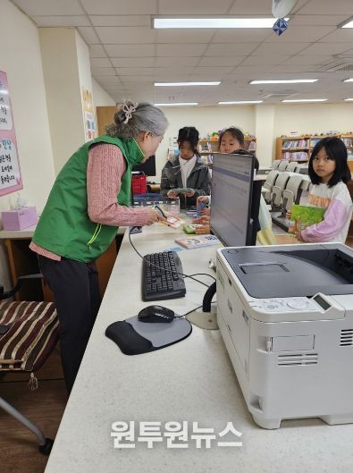 전남선배교직원교육지원봉사센터 자원봉사자가 학교도서관에서 자원봉사를 하고 있는 모습