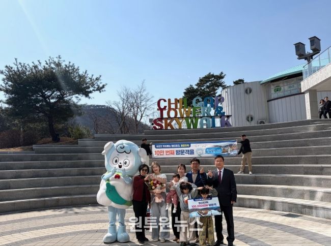 지난 22일 청양 칠갑타워에서 열린 10만 방문객 돌파 기념 이벤트에서 강희선 관광진흥과장(오른쪽 끝)이 10만 번째 방문객 임연옥 씨(왼쪽에서 다섯 번째)에게 기념품을 전달한 뒤 기념 촬영을 하고 있다.