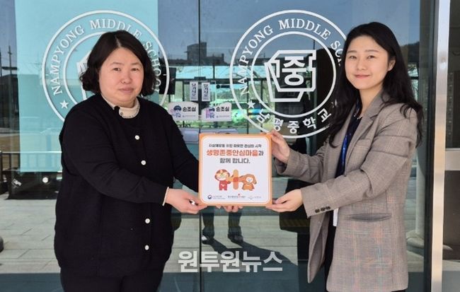 나주시보건소가 남평중학교에 생명 존중 안심마을 현판을 전달하고 있다.